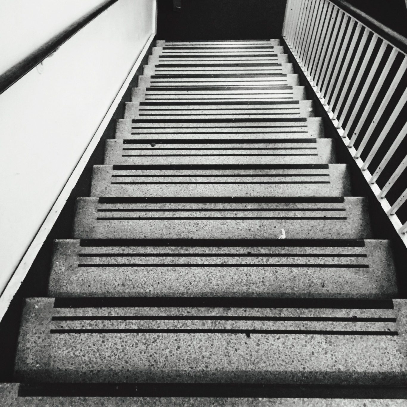 Cadre stratégique et positionnement de marque — VISUELROUGE Escalier en béton avec rampes, vu de bas en haut.